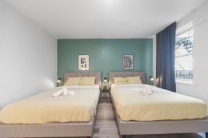 two beds sitting next to each other in a bedroom at Modern and cozy 4 bedrooms sleep 12 in Montreal