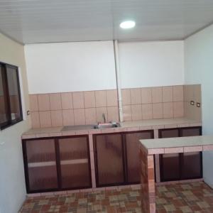an empty kitchen with a sink and a counter at Apartamentos HJJ in Puerto Limón