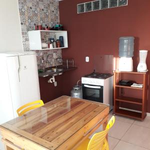 uma cozinha com uma mesa de madeira e um fogão em Pousada Caribe Milagrense em São Miguel dos Milagres