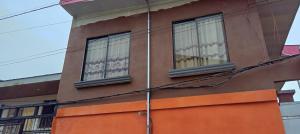 budynek z dwoma oknami na boku w obiekcie Apartamentos HJJ w mieście Puerto Limón