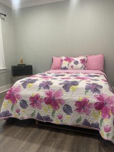 - une chambre avec un lit et une couette à fleurs dans l'établissement SUITE DREAMs BLOOMFIELD 36, à Bloomfield