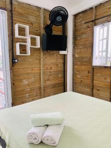 a bedroom with a bed with two towels on it at Suítes Cabanas Coral in Serra