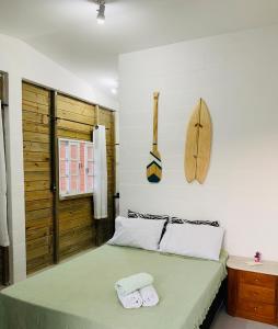 a bedroom with a bed with two towels on it at Suítes Cabanas Coral in Serra