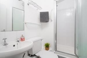 a white bathroom with a toilet and a shower at Modern 4-bedroom Apartment in Fulham, London in London