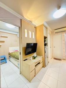 Cette chambre comprend un lit et une télévision sur un bureau. dans l'établissement 2 Bedrooms Apartment Strategic Location Affordable for All, à Jakarta