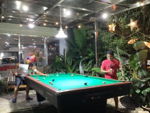eine Gruppe von Menschen, die eine Partie Billard spielen in der Unterkunft La Casa Teresa Tourist Inn in El Nido