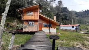 ein Haus mit einem Holzsteg, der dorthin führt in der Unterkunft Killary, Laguna de La Cocha in Pasto