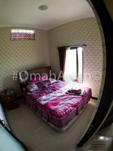 a bedroom with a bed in a room with a mirror at Omah Awan at Desa Wisata Petik Jeruk Selorejo in Sengon
