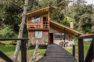a house in the woods with a wooden walkway at Killary, Laguna de La Cocha in Pasto