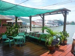 a deck with tables and chairs and boats in the water at Oceanblue Guesthouse in Ko Chang +22 photos