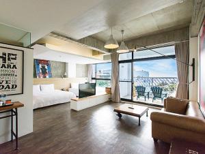 ein Hotelzimmer mit einem Bett, einem Sofa und einem TV in der Unterkunft El Puerto Hotel in Eluan