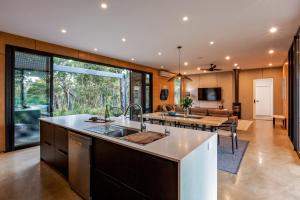 an open kitchen and living room with a table at Eagle Rise Plus Studio in Dunsborough