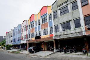 um edifício colorido com motos estacionadas em frente em Hotel Capital Cikokol RedPartner em Kebonnanas