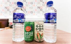 duas garrafas de água sentadas em cima de uma mesa em From H sum Hotel Daejeon em Daejeon