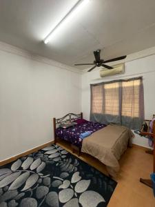 a bedroom with a bed and a ceiling fan at Family's Homestay in Kuala Terengganu