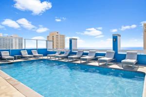 - une piscine sur le toit d'un immeuble avec des chaises dans l'établissement Cozy Apt in Pacific Monarch - 1 Block to Beach!, à Honolulu
