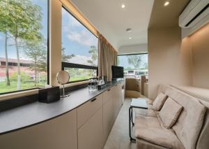 a living room with a couch and a large window at The Bus Collective in Singapore