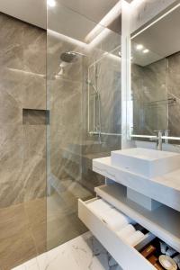 a bathroom with a sink and a glass shower at Kinaralana Hotel Yogyakarta in Yogyakarta +24 photos