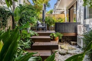 un petit jardin avec des marches et des plantes en bois dans l'établissement Urban Green - Stylish Courtyard Haven off Malvern Rd, à Melbourne