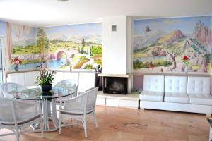 une salle à manger avec une table et des chaises ainsi qu'une fresque murale. dans l'établissement La Casa di Mimma, à Caposele