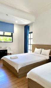 a bedroom with two beds and a window at Bamboo Hotel Vung Tau in Vung Tau