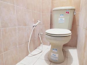 La salle de bains est pourvue de toilettes avec un tuyau. dans l'établissement RedDoorz at DeAmartaLoka Colomadu Solo, à Colomadu