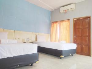 - une chambre avec 2 lits et une fenêtre dans l'établissement RedDoorz at DeAmartaLoka Colomadu Solo, à Colomadu