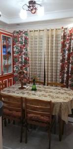 a dining room with a table and chairs and curtains at Charming Getaway @ The City of Pines in Baguio