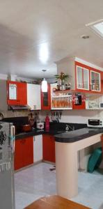 una cocina con armarios rojos y blancos y una encimera en Charming Getaway @ The City of Pines en Baguio