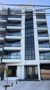 a building with a palm tree in front of it at Remanso de Mar in Mar del Plata
