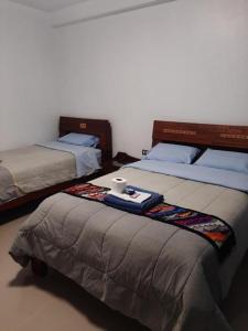 1 dormitorio con 2 camas y bandeja. en HOTEL SÚMAQ PUÑUY, en Yungay