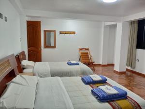 a hotel room with two beds and a chair at HOTEL SÚMAQ PUÑUY in Yungay