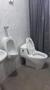 y baño con aseo, urinario y lavamanos. en HOTEL SÚMAQ PUÑUY, en Yungay