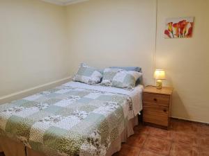 a small bedroom with a bed and a night stand at Casa interior Playa Brava in Iquique