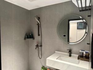 a bathroom with a shower and a sink and a mirror at MuMu Hotel Changsha in Changsha