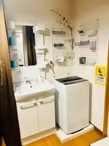 a white bathroom with a sink and a mirror at Yuyu House Kohama Teru - Vacation STAY 15334 in Osaka