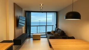 a living room with a couch and a view of the ocean at Remanso de Mar in Mar del Plata