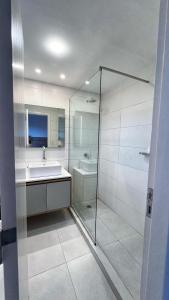 a bathroom with a glass shower and a sink at Remanso de Mar in Mar del Plata +8 photos