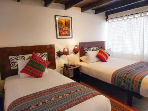 a bedroom with two beds and a window at SACRED STONE Boutique Hotel in Machu Picchu