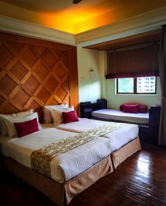 a hotel room with two beds and a window at Langkawi Lagoon Resort Seaview in Pantai Cenang