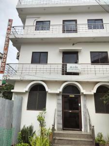 um edifício branco com uma escada em frente em RK GUEST HOUSE em Bodh Gaya