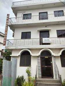a large white building with a balcony and a door at RK GUEST HOUSE in Bodh Gaya