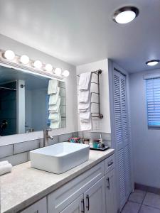 W łazience znajduje się duża, biała umywalka i lustro. w obiekcie Water Front House w mieście Providenciales