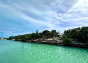 a large body of water with a house on the shore at Water Front House in Providenciales