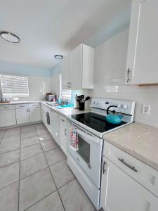 a kitchen with white cabinets and a stove top oven at Water Front House in Providenciales