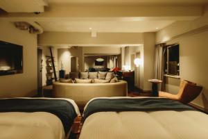 a living room with two beds and a couch at THE KNOT TOKYO Shinjuku in Tokyo