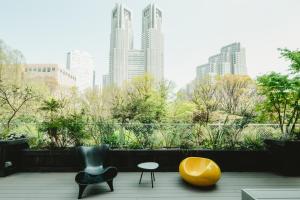 a balcony with two chairs and a yellow chair at THE KNOT TOKYO Shinjuku in Tokyo