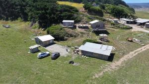 una vista aérea de una granja con coches estacionados en un campo en Cabañas la puntilla montaña río y mar, en San Antonio