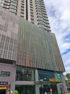 Un edificio alto con un cartel en el frente. en jazz suite 2 bedroom sea view apartment, en Tanjung Bungah