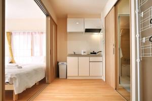 um pequeno quarto com uma cama e uma janela em Edogawa Japanese Style Apartment 201 has direct access to Akihabara and Shinjuku, with convenient transportation and free WiFi em Tóquio